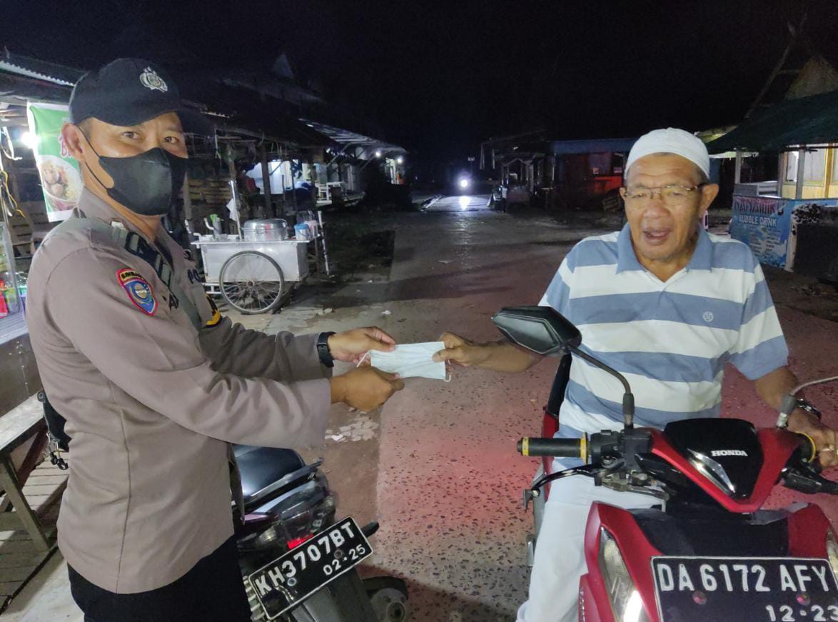 Bhabinkamtibmas memberikan Sosialisasi Protokol Kesehatan dan bagikan masker