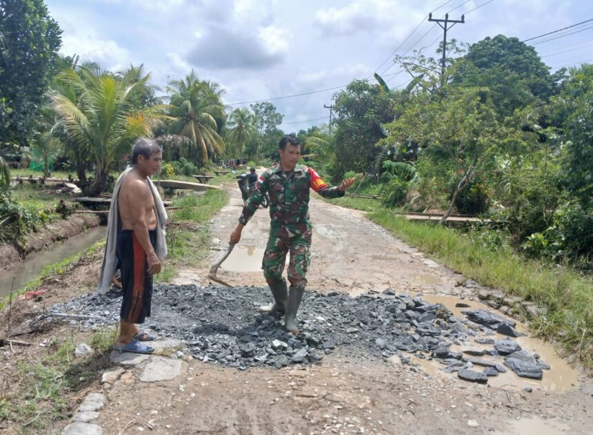 Babinsa Desa Ratu Sepudak Bersama Warga Gotong Royong Timbun Jalan Berlubang