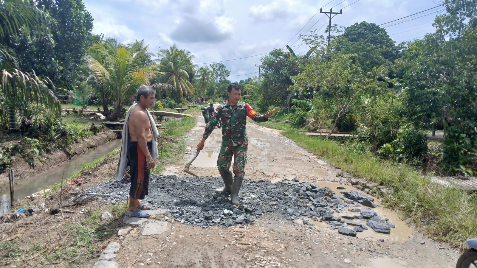 Babinsa Desa Ratu Sepudak Bersama Warga Gotong Royong Timbun Jalan Berlubang
