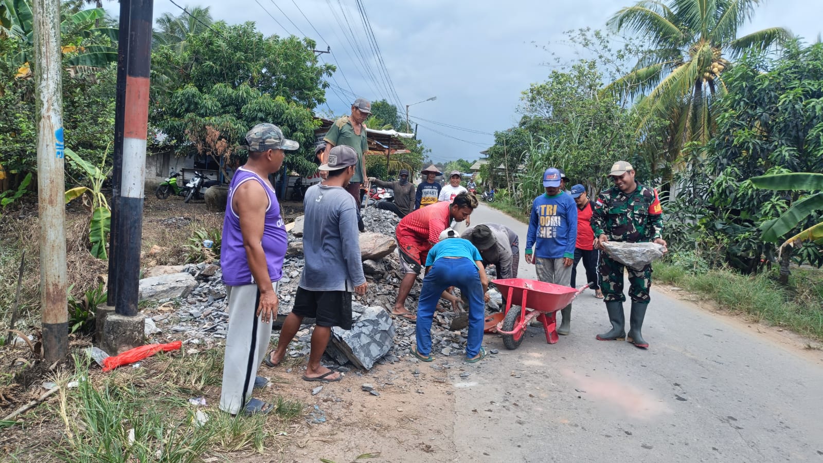 Babinsa Merubung Koramil 03/Tebas Ajak Warga Gotong Royong Timbun Jalan Gang Wilayah Binaan
