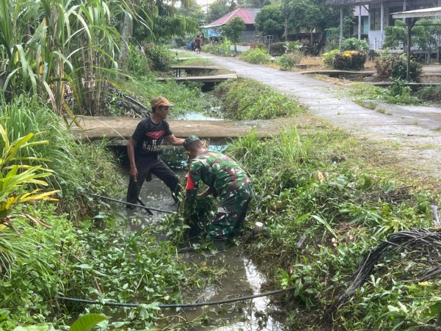 Cegah Timbulnya Penyakit di Musim Hujan, Babinsa Koramil 02/Sejangkung Bersama Warga Gotong Royong Bersihkan Parit